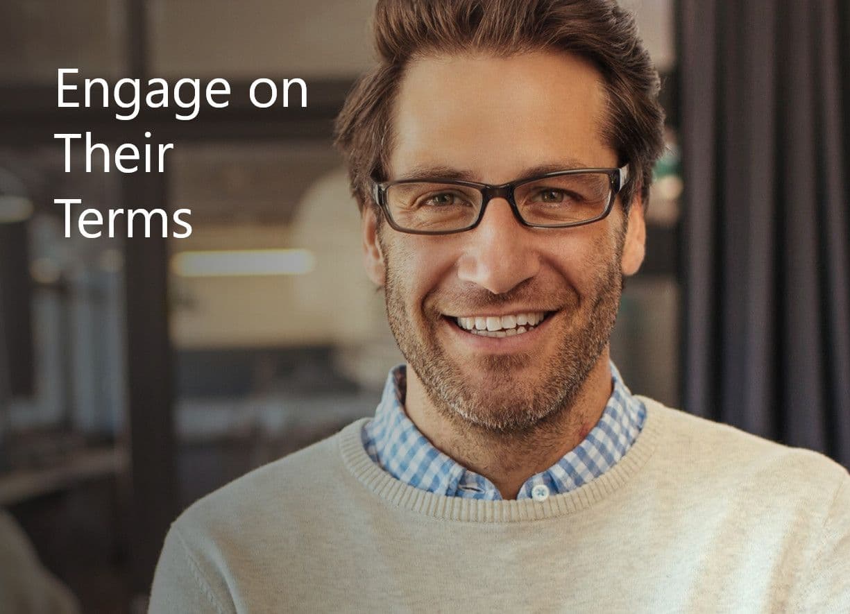 Smiling man in glasses with text overlay: Engage on Their Terms.