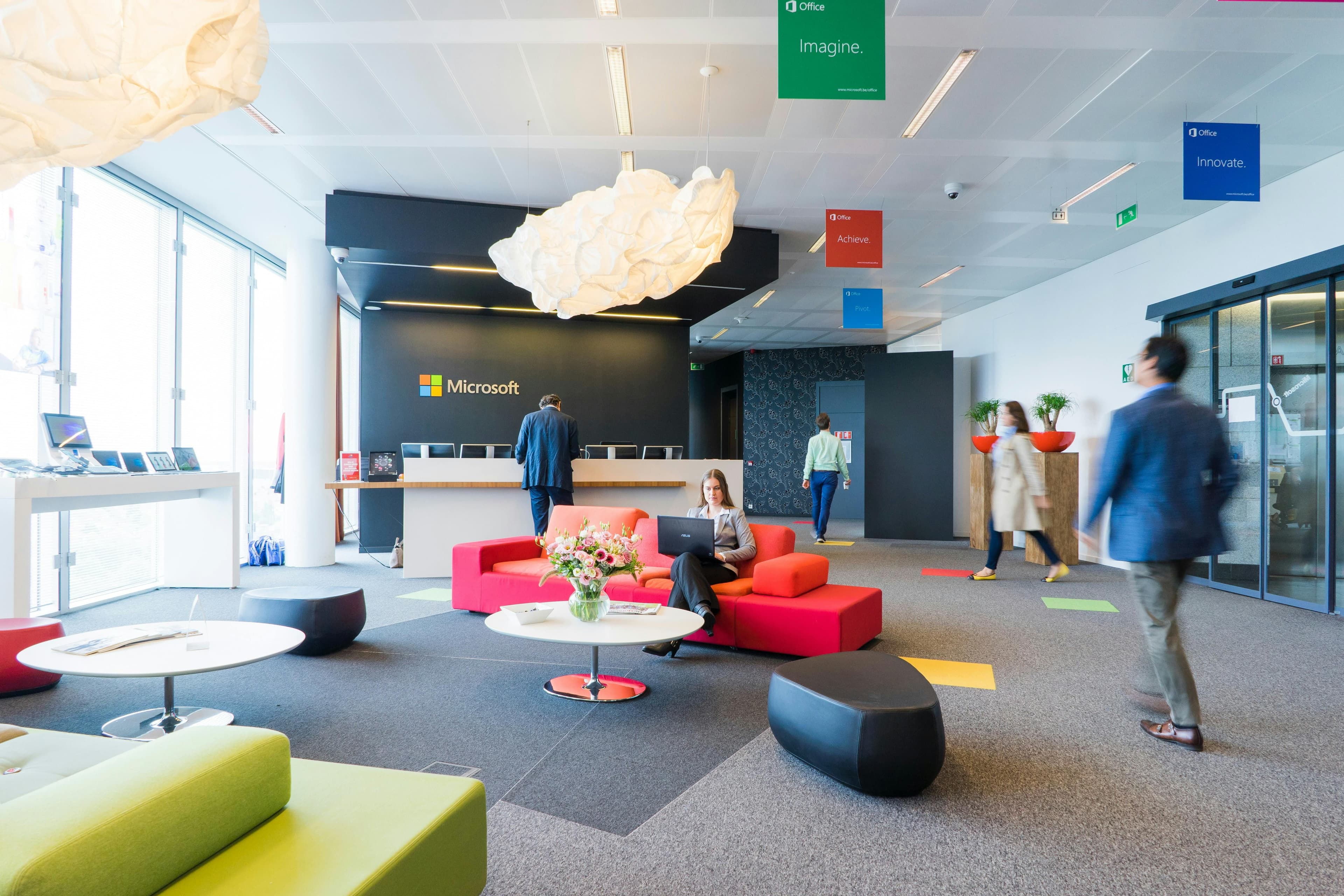 Modern Microsoft office lobby with people, colorful furniture, and unique light fixtures.
